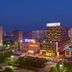 Zhucheng Huaxi Grand Hotel in Rizhao at night, with city skyline and lit hotel facade.