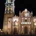 Hotel Boutique Casareyna in Puebla City with a lit historic cathedral facade at night