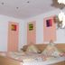 Jaegerstube in Görgeshausen bedroom with wooden bed, patterned bedding and colorful wall art