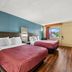 Econo Lodge Charlotte Airport Area room with two beds, wood floors, and a window view in Charlotte