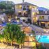 Asion Lithos in Kato Asites with lit stone villas and a glowing outdoor pool at sunset