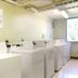 Residence & Conference Centre - Oakville laundry room with row of washers and dryers