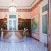 Hotel Maderno lobby with chandelier, curved reception desk and painted walls in Toscolano Maderno