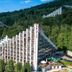 Hotel Diament Ustron in Ustroń with a triangular glass facade set against forested hills