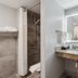 AmericInn by Wyndham Wisconsin Dells bathroom with granite vanity and walk-in shower