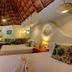 Riviera Maya Suites in Playa del Carmen guest room with two beds, thatched ceiling, and seating area