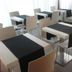 Hotel La Rosta in Reggio nell'Emilia dining area with white tables, beige chairs and black runners