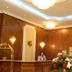 Santa Beach Hotel in Agía Triáda lobby reception with wood-paneled walls, chandelier lighting, and flower arrangement