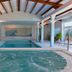 Hotel Fraga do Eume in Capela indoor pool with hot tub, wood-beamed ceiling and lounge chairs
