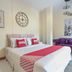 OYO 1134 Baan Zarn Guesthouse Patong room with double bed, purple sofa, and wall art