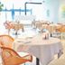 Bij Jef in Den Hoorn dining room with white tablecloth tables and wicker chairs
