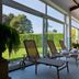 Sunlit indoor lounge with loungers beside large windows at Hotel Fraga do Eume in Capela