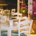 Kyparissia Blue Boutique Hotel in Kyparissía patio dining area with white chairs and tables beside pink flowers