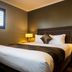 The Waverley International Hotel in Glen Waverley guest room with king bed and bedside lamps
