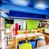 ibis budget Dandenong breakfast area with colorful chairs, tables, and buffet counter