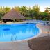 The Kairaba Beach Hotel in Serrekunda with a large outdoor pool, thatched bar, and palm trees