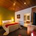 Tall Timbers Tasmania in Smithton guest room with bed, bedside lamps, wood ceiling, and TV