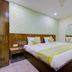 Hotel Daya Continental, New Delhi: double bed in a guest room with wood headboard and mirror