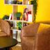 Le Clocher de Rodez in Toulouse lobby seating area with yellow wall, shelves, and round table