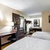 Red Roof PLUS+ Nashville South - Fairgrounds room with two beds, desk, microwave, and mini fridge