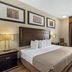 Best Western Plus St. Albert guest room with king bed, desk by window, and framed wall art in Saint Albert