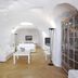 Aghios Artemios Traditional Houses in Thera, cave-style room with white sofa, bed, and arched ceiling