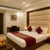 Hotel Impress By Rmr Hotels in New Delhi bedroom with king bed, desk, bedside lamps, and fruit tray