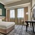 Vibe Hotel Singapore Orchard guest room with king bed, desk and city-view window in Singapore