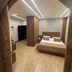 Lamedina Hotel & Resort in Jounieh bedroom with wood accents, double bed, and modern ceiling lights