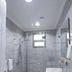 Plaza Athenee Hotel in Kuwait City bathroom with glass shower, wall-mounted sink and toilet