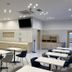 Toyoko Inn Tobu Utsunomiya eki Nishi guchi breakfast area with tables, chairs, counter and wall-mounted TV in Utsunomiya