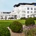 Kurhotel Skodsborg in Copenhagen with a white hotel facade, manicured lawn, and landscaped garden