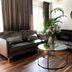 Åsby Hotell in Hallstahammar lounge with dark sofas, glass coffee table and floral arrangement
