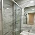 Villa Montmartre Paris bathroom with glass shower, marble-look walls, sink and mirror