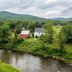 The Woodbridge Inn in Woodstock overlooking a river, green hills, and red and white houses