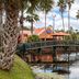 Baymont Inn & Suites Lake City with palm-lined pond, fountain, and bridge beside the hotel
