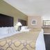 Baymont Inn & Suites Lake City guest room with two beds, desk, TV, and bathroom vanity