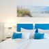 Hotel Nordraum in Bremen guest room with twin beds, blue chairs, and seaside wall art
