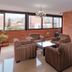 Hotel San Pedro del Fuerte in Medellín lounge with striped armchairs, table, chandelier and city views