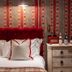 Cotswold Plough Hotel & Restaurant in Bampton bedroom with red tufted headboard and patterned wallpaper