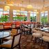 Hilton Garden Inn St. Louis Airport dining area with tables, chairs and large windows overlooking patio seating