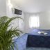 Terme Miramonte e Mare room in Casamicciola Terme with blue bed, wall TV, window and potted plant