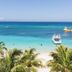 Henry Morgan Hotel & Beach Resort in Coxen Hole with palm trees, white sand beach, and turquoise ocean view