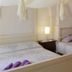 Masseria Pelosella B&B in Fasano, airy guest room with canopy bed and twin sofas