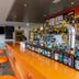 Hotel Valle de Cabezón bar with orange counter, stools and drinks in Cabezón de la Sal