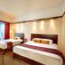 Millennium Hotel Sirih Jakarta guest room with two beds and city-view window in Jakarta