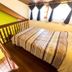 Pouso Sambaquis in Ilhabela, loft bedroom with bed beside curtained window and wooden railing