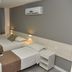 Hotel Três Caravelas in Fortaleza: twin beds, wall lamps, curtains, and wall-mounted air conditioner