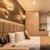 The Waverley International Hotel in Glen Waverley guest room with double bed, wardrobe and wall sconces