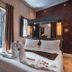 Ambre Epices Medina Riad in Marrakech, a bedroom with towel swans, open balcony doors and patterned wall